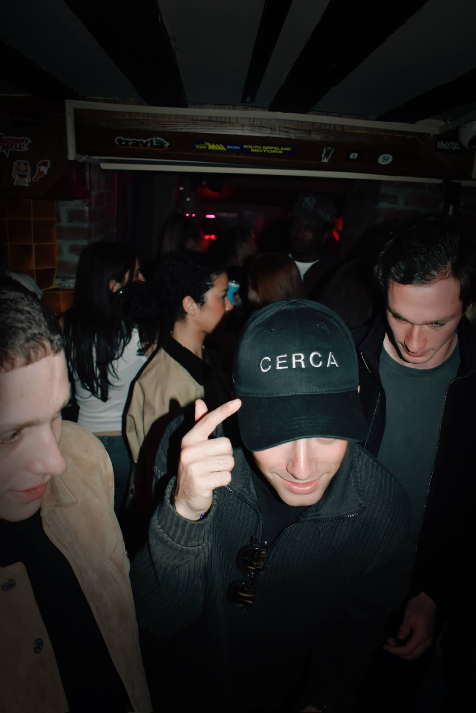 Guests at a Cerca event with branded cap and dark party lighting.